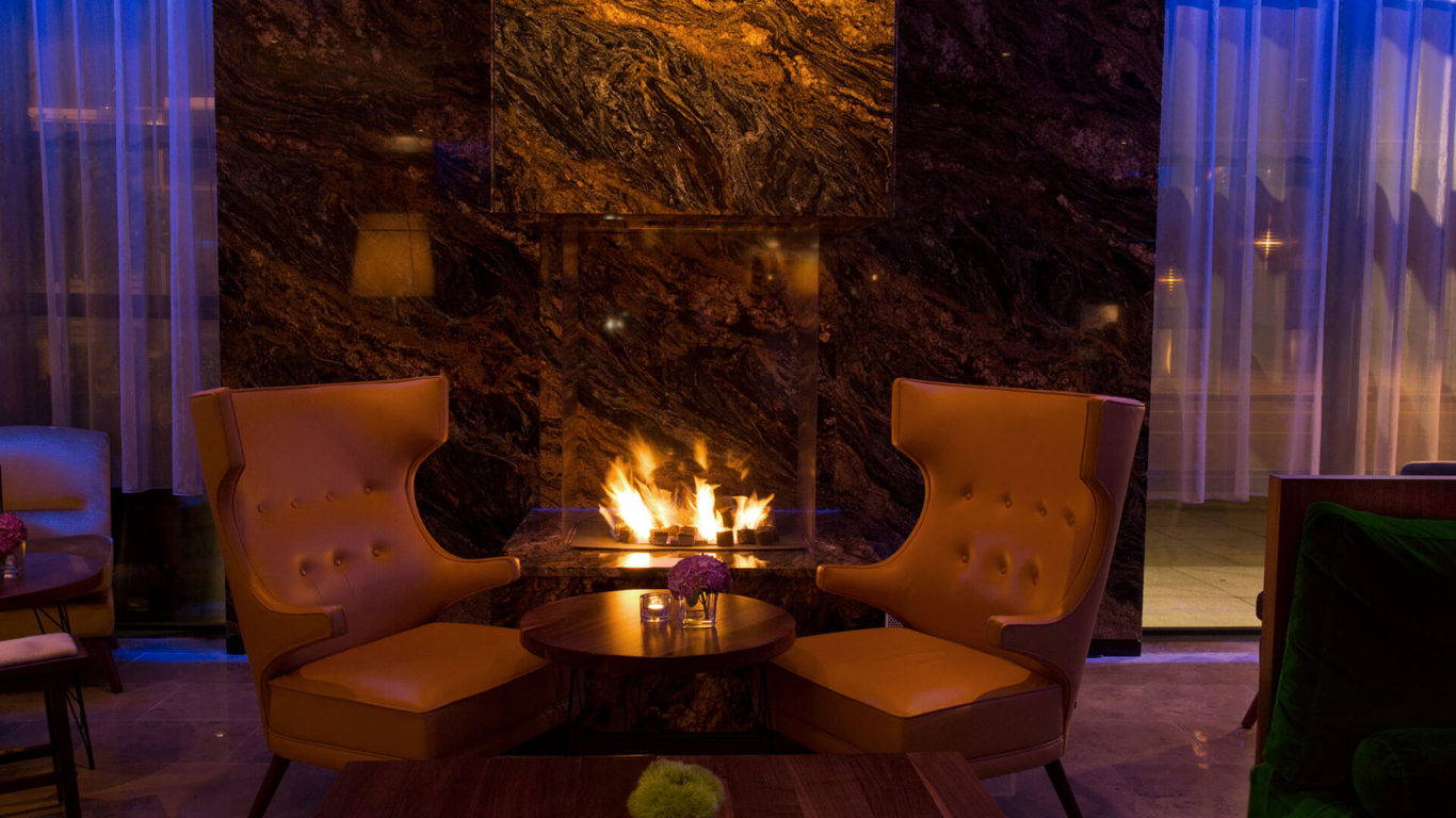 Two leather chairs in front of a roaring fire in the Lobby Lounge