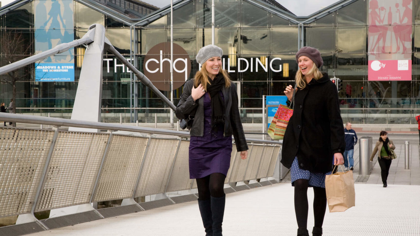 Two women walking across the river Liffey after Shopping at the CHQ building