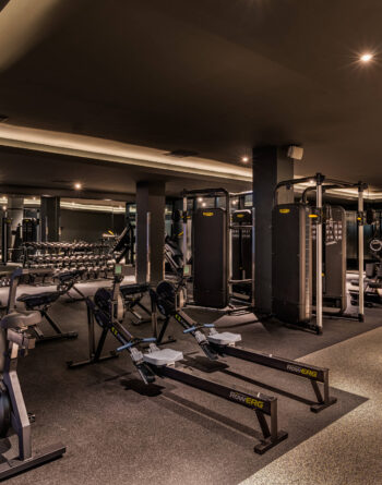 Modern gym room with state-of-the-art equipment at luxury hotel, perfect for fitness enthusiasts.