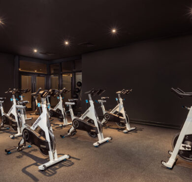 Modern fitness centre with spin bikes under soft lighting, offering a perfect workout environment for hotel guests.