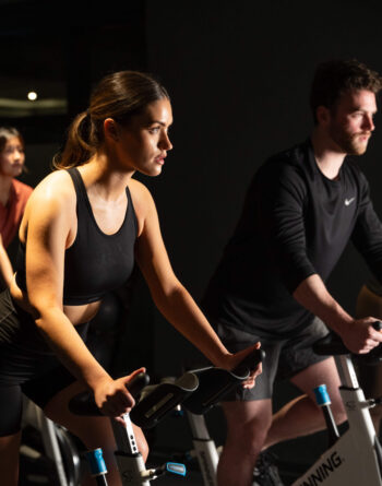 Guests enjoy an energetic group cycling class in the hotel's modern fitness centre, featuring state-of-the-art equipment.