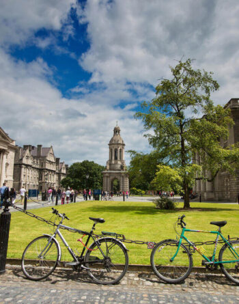 Scenic courtyard with bikes, historic architecture, and lush greenery for guests at a charming city hotel.