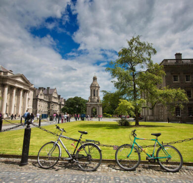 Scenic courtyard with bikes, historic architecture, and lush greenery for guests at a charming city hotel.