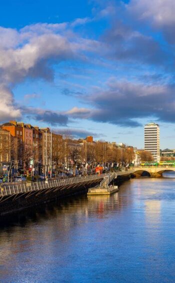 Panoramic river view from hotel room, vibrant cityscape, historic buildings, and blue sky in Dublin. Perfect urban escape.