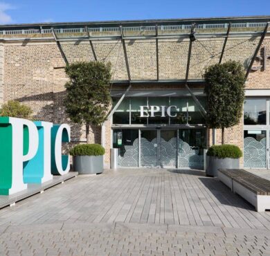 Stylish hotel entrance with modern decor, lush greenery, and sleek seating, welcoming guests for a luxurious stay.