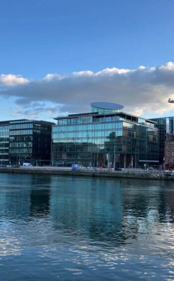 Modern riverside hotel with stunning glass architecture and vibrant skyline, perfect for luxury stays in the city.